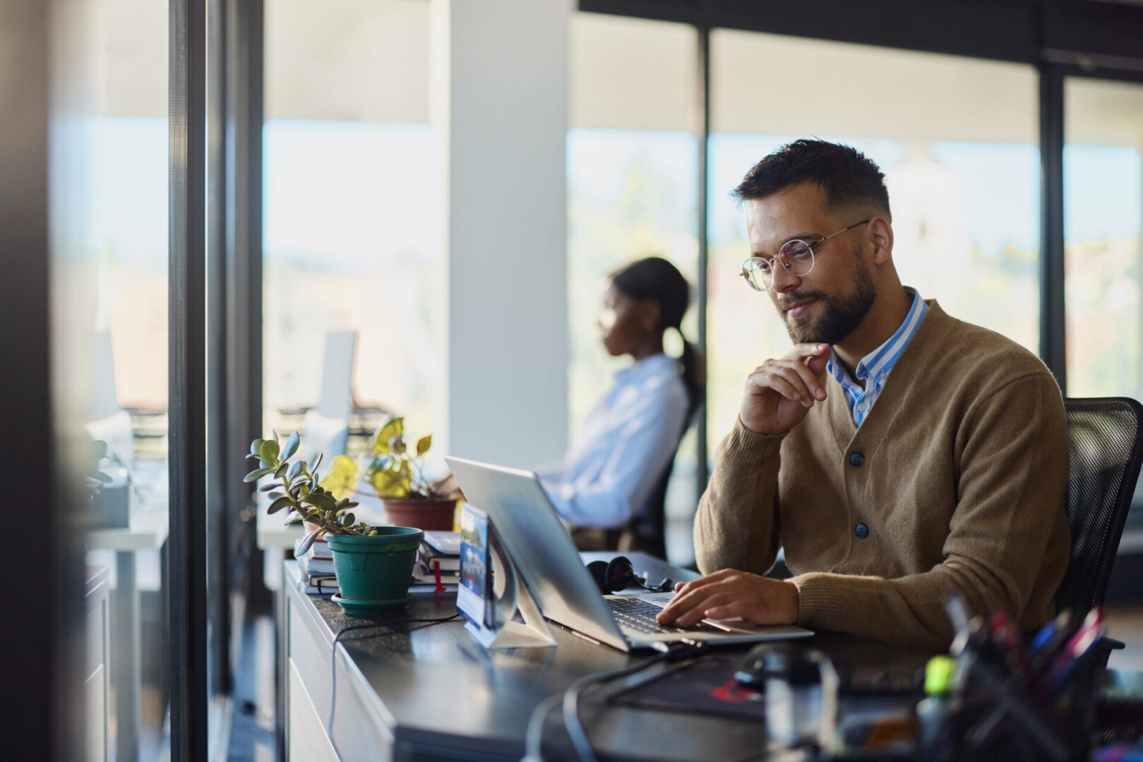 Man working at desk with laptop.